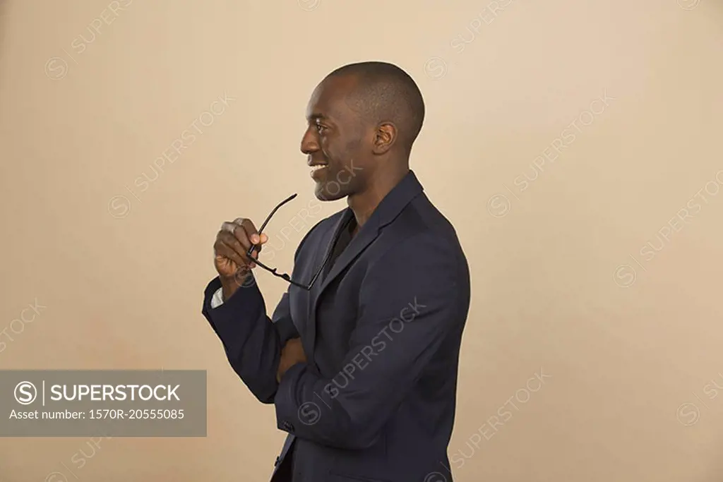Thoughtful man smiling while looking away against colored background