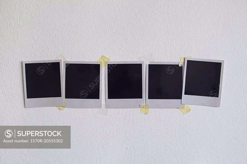 Blank instant camera prints stuck on white wall