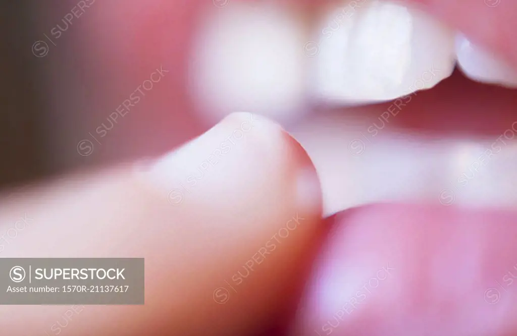 Extreme close-up of finger touching lips