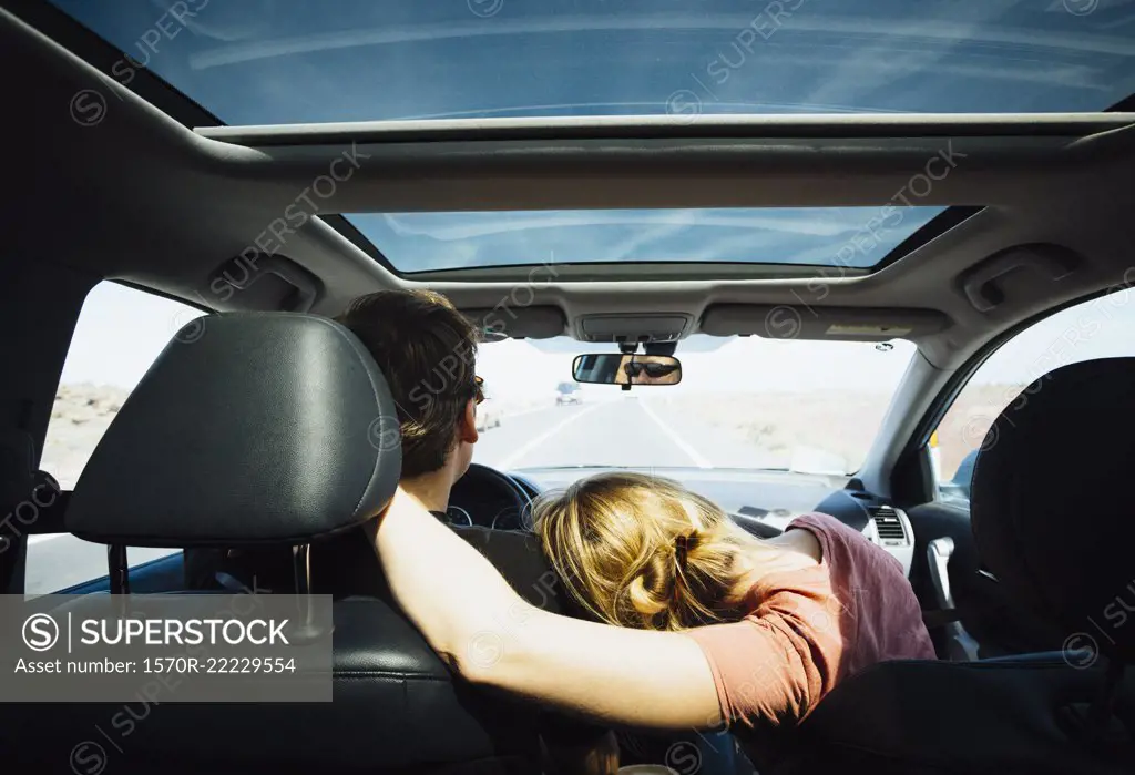 Affectionate couple riding in sunny car