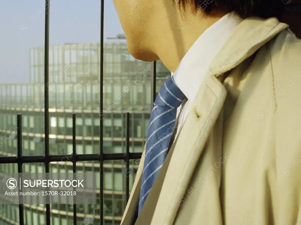 A businessman peering down from a building