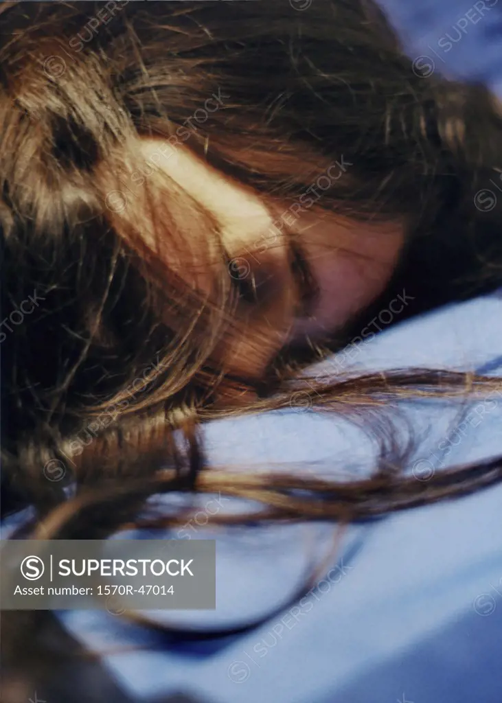 A woman sleeping with her hair covering her face