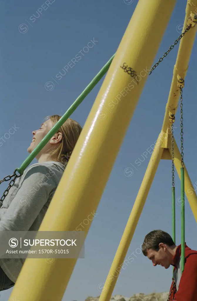 A couple swining at a playground