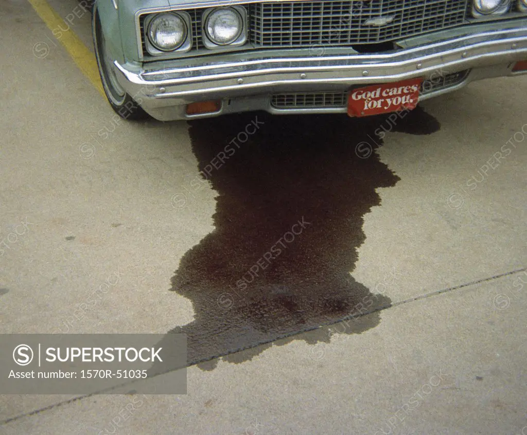 A car leaking fluid onto the pavement