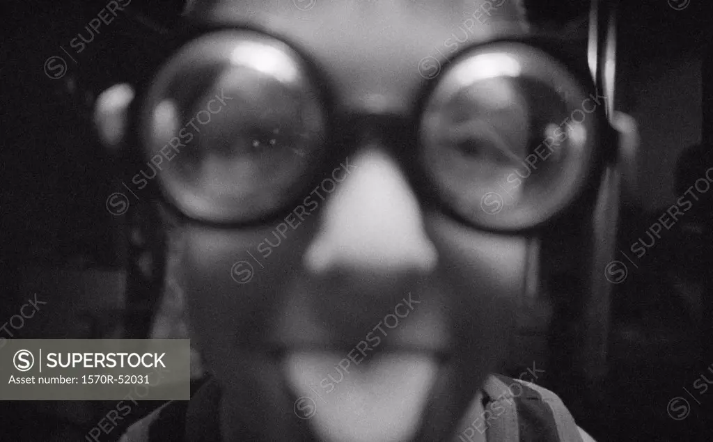 A teenager wearing funny glasses sticks his tongue out