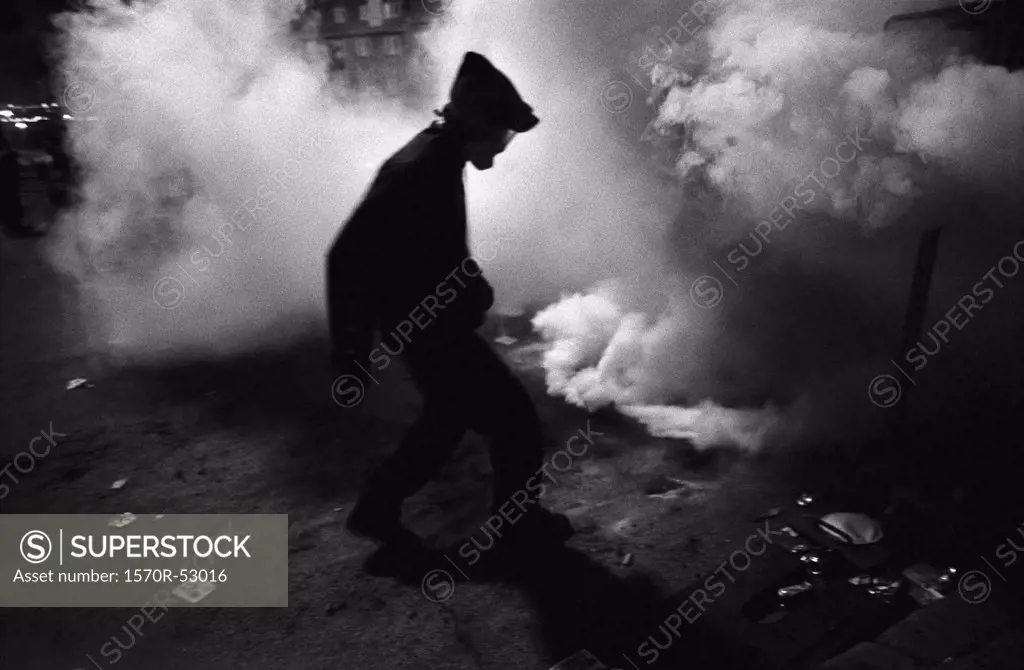 A political protester surrounded by tear gas