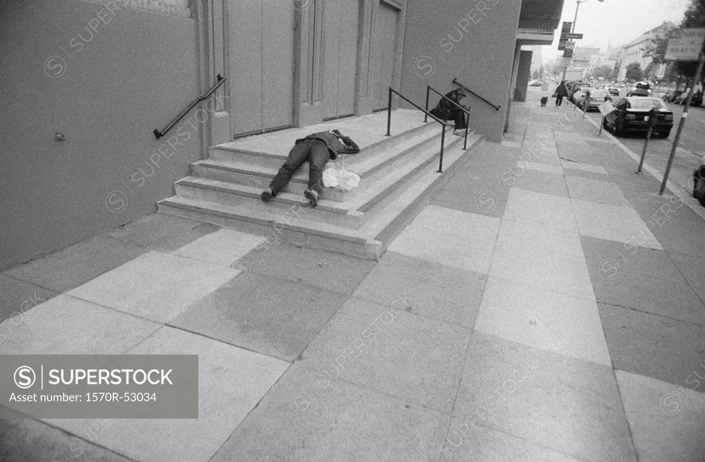 A man lying on concrete steps