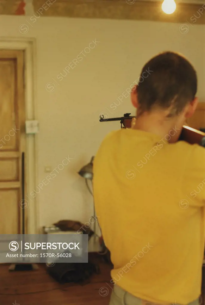 A man aiming a rifle at a door