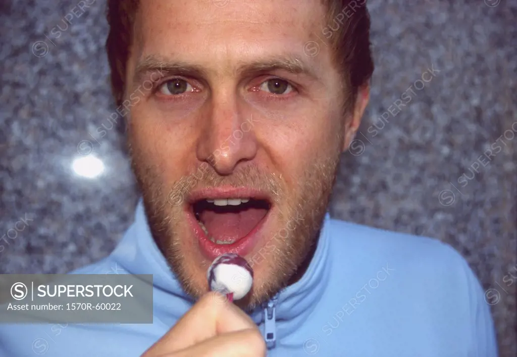 A man holding a lollipop