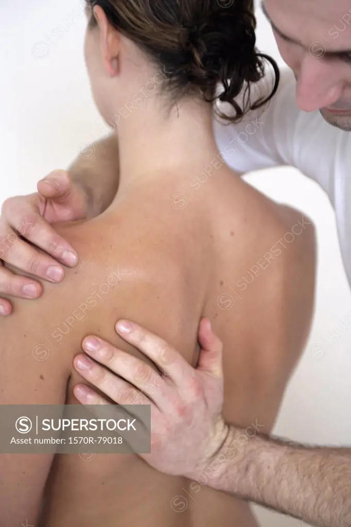 A massage therapist massaging a woman's back