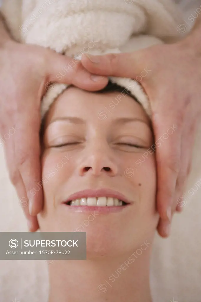 A massage therapist massaging a woman's face