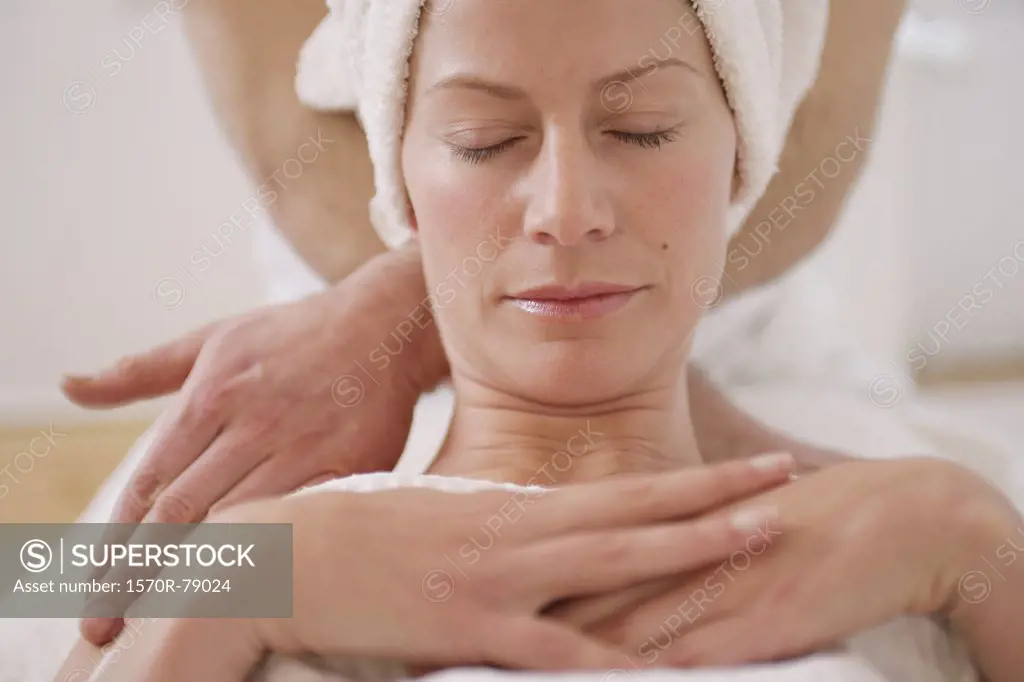 A massage therapist massaging a woman's neck