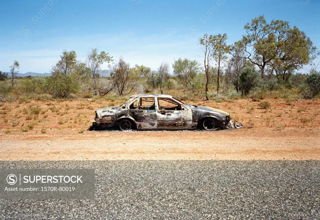 An abandoned car on the side of a desert road, Australia