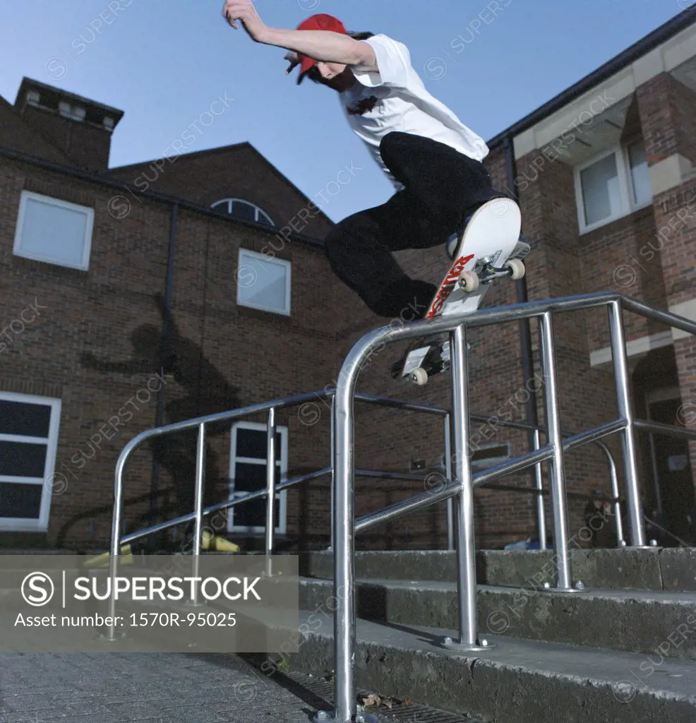 Man on skateboard balancing on railing 