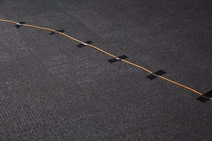 High angle view of cables attached on black carpet