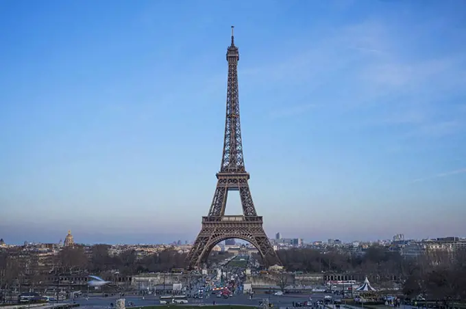 Eiffel tower in city against blue sky