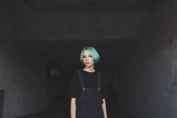 Portrait of teenage girl standing in basement