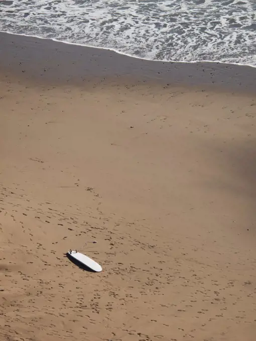 High angle view of surfboard on sand at beach