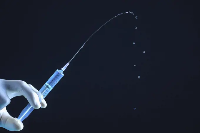 Close up liquid squirting from syringe