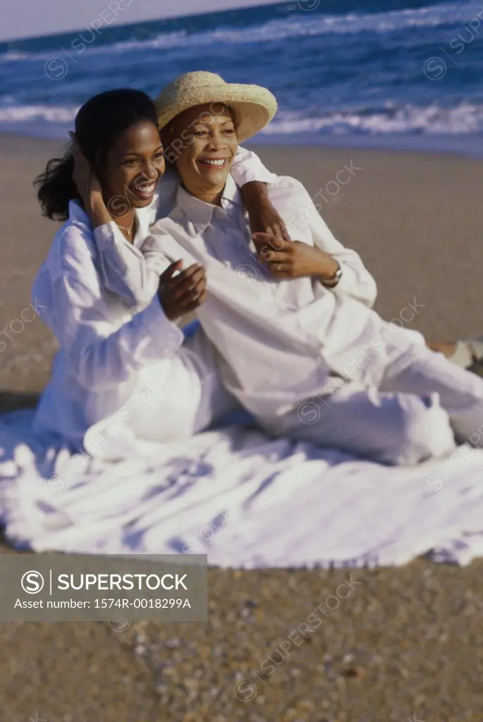 Mother sitting with her daughter on the beach