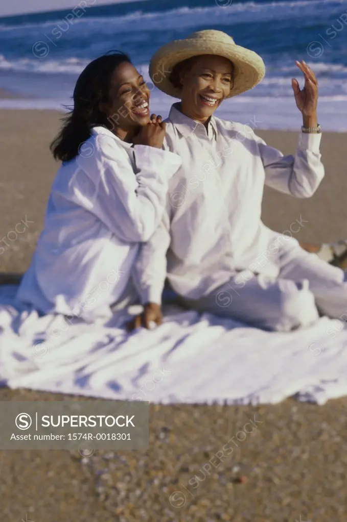 Mother sitting with her daughter on the beach