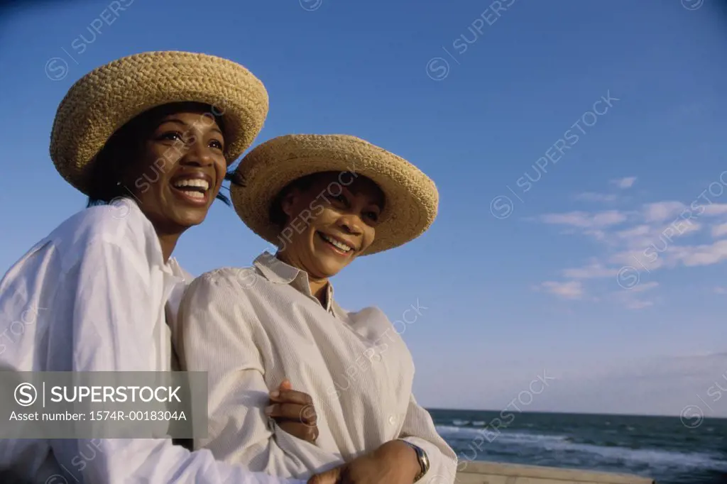 Close-up of a mother and daughter smiling on the beach
