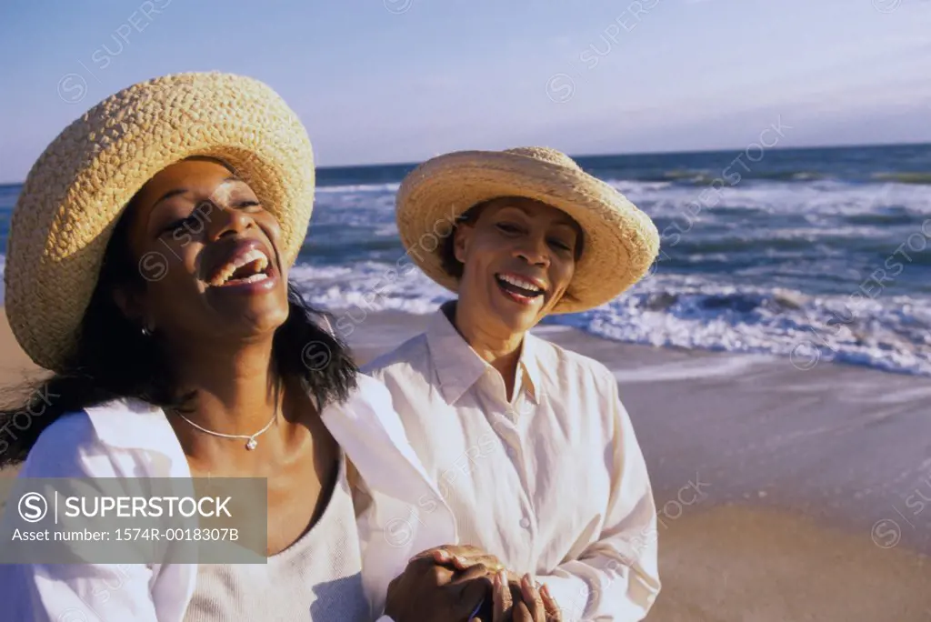 Mother laughing with her daughter on the beach