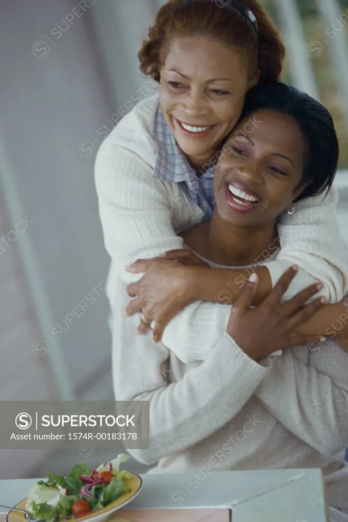 Close-up of a mother hugging her daughter smiling