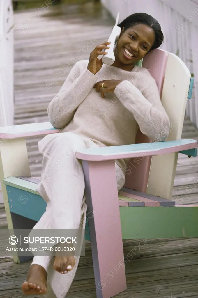 Young woman sitting in a chair talking on a telephone