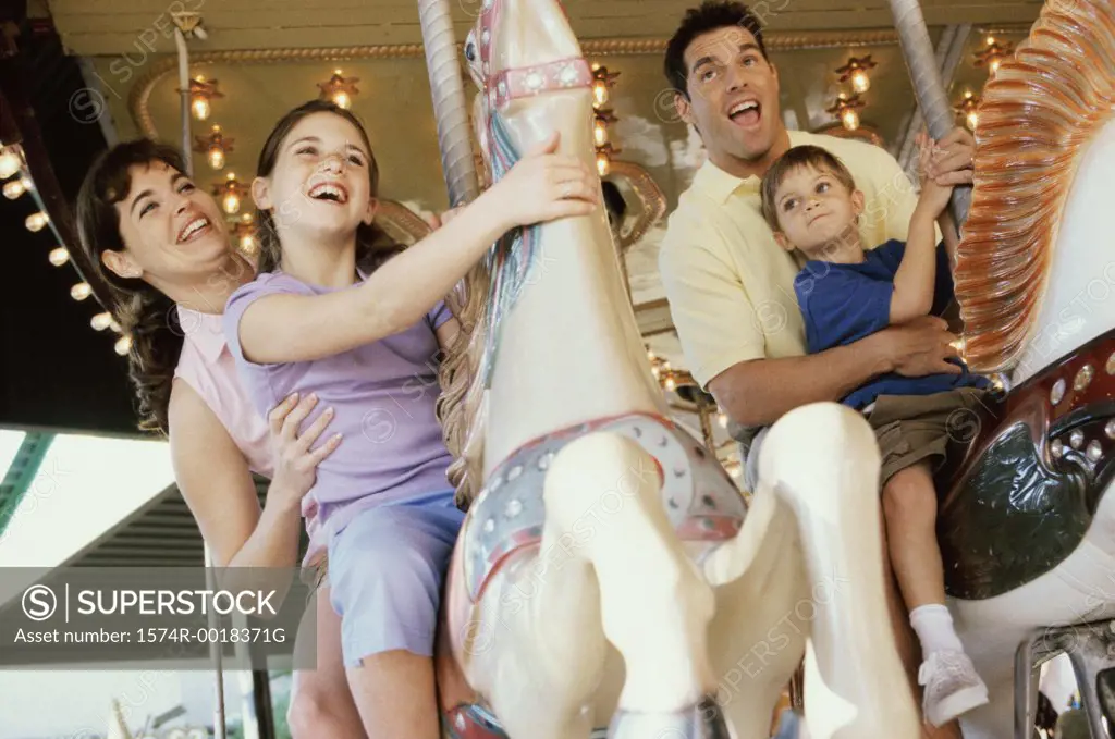 Low angle view of parents with their son and daughter on a carousel