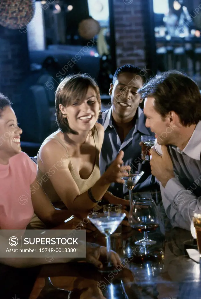 Two young couples in a bar smiling