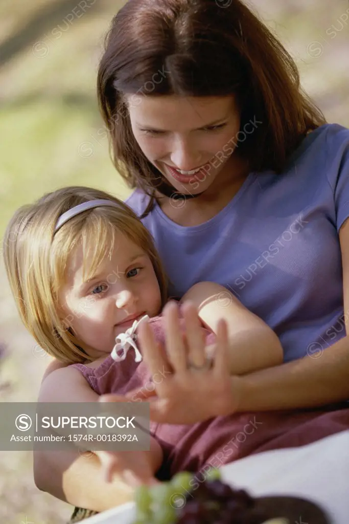 Close-up of a daughter sitting on her mother's lap