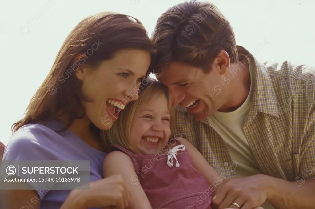 Close-up of parents and their daughter laughing