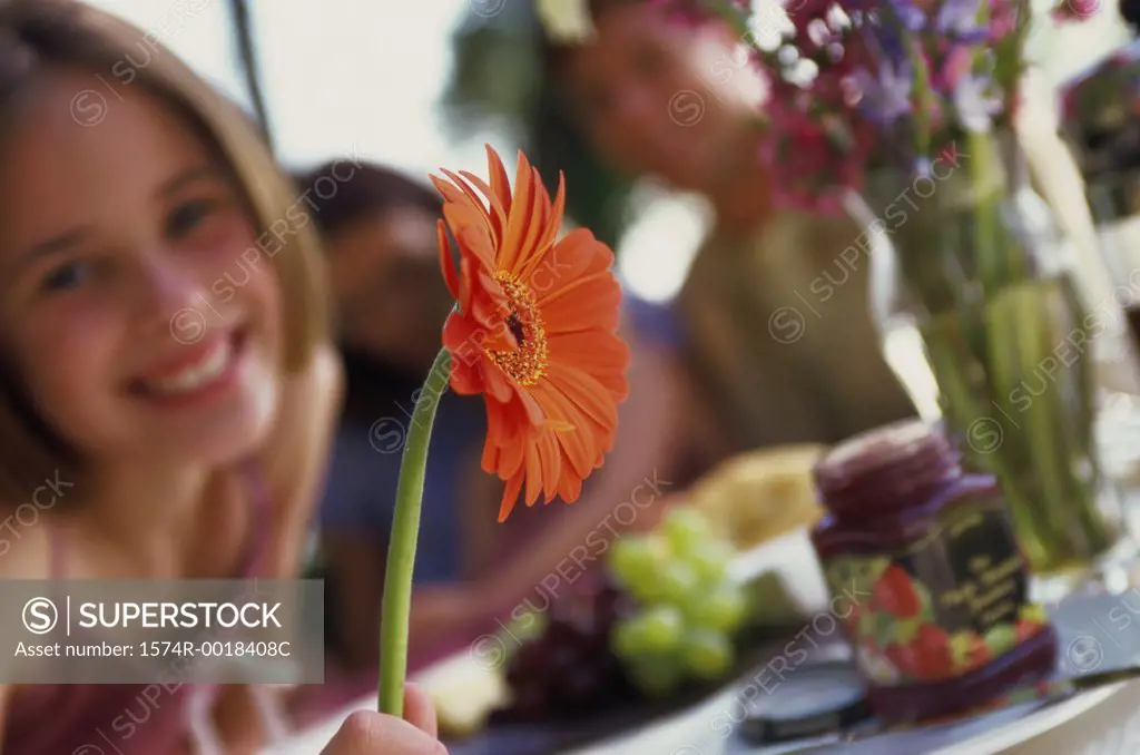 Portrait of a girl holding a flower and smiling