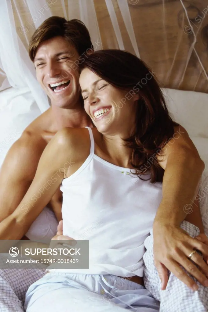 Young couple sitting on a bed