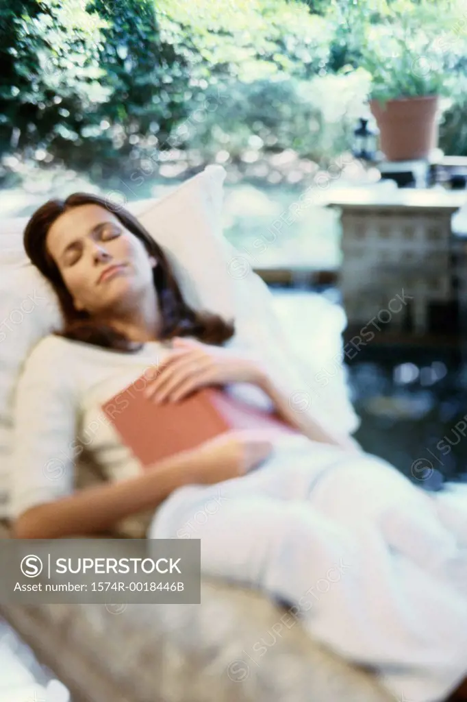Young woman asleep with a book on her chest