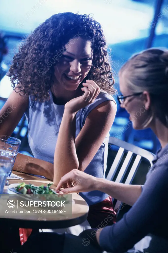 Close-up of two young women smiling in a restaurant