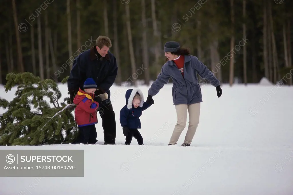 Parents walking on snow with their son and daughter