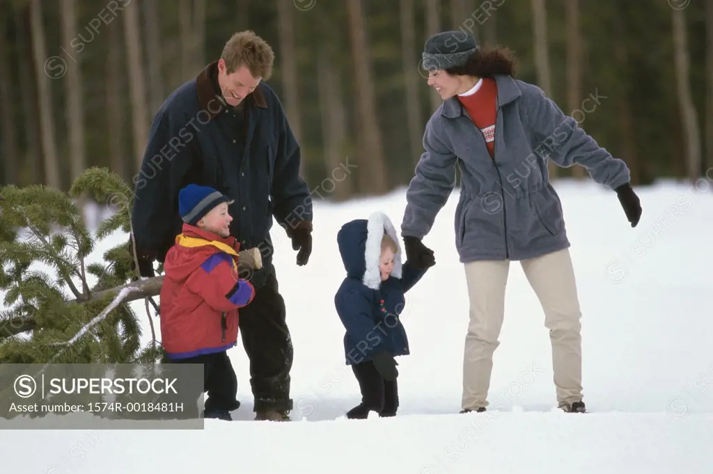 Parents walking on snow with their son and daughter