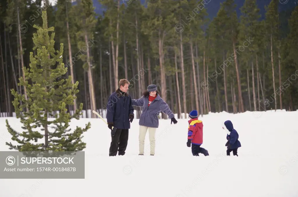 Parents playing with their son and daughter on snow