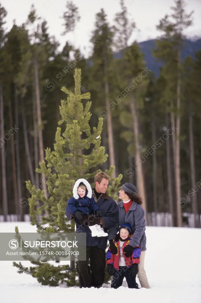 Parents standing with their son and daughter on snow