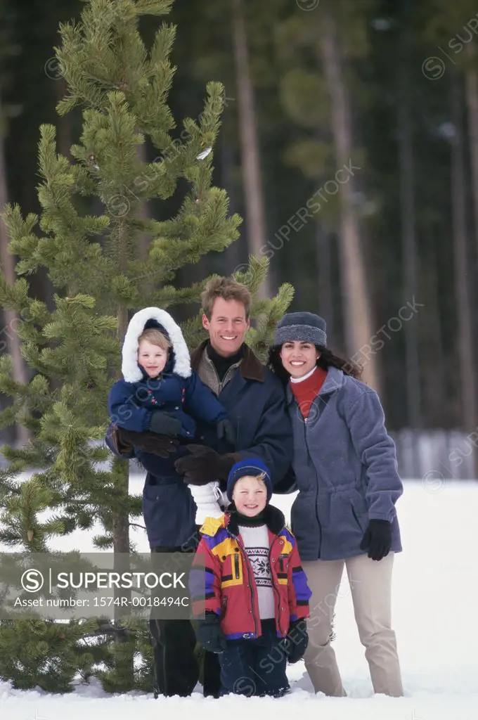 Portrait of parents standing with their son and daughter on snow