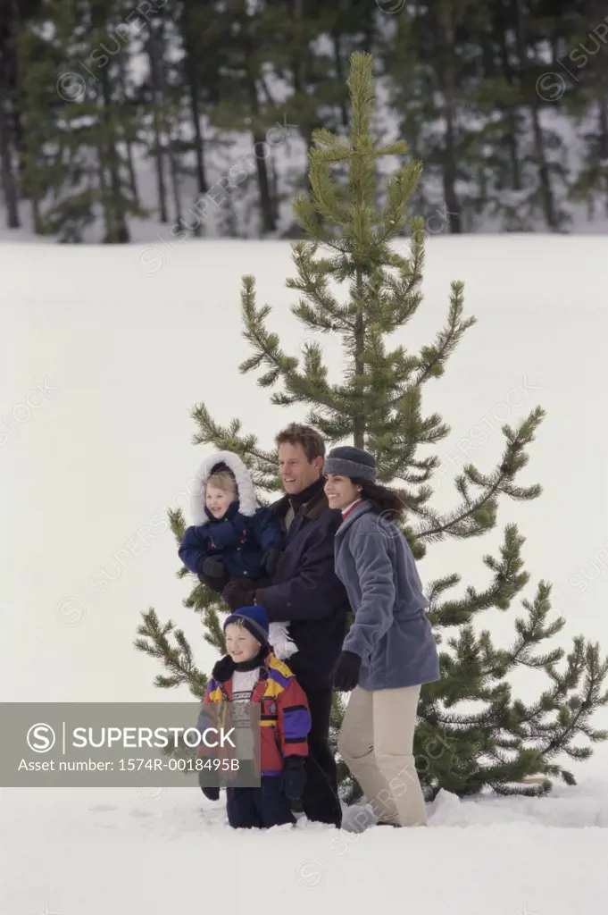 High angle view of parents standing with their son and daughter on snow