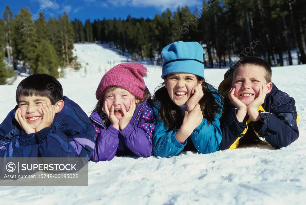 Portrait of a group of children lying in snow