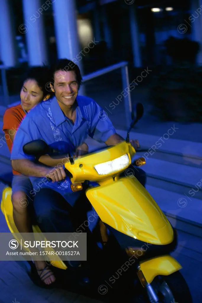 Young couple riding on a scooter