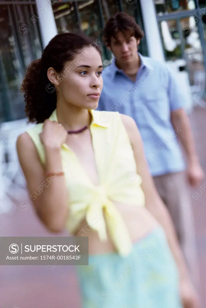 Teenage girl with a young man standing behind her