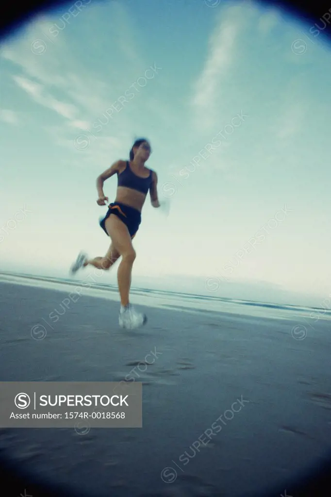 Low angle view of a young woman running on the beach