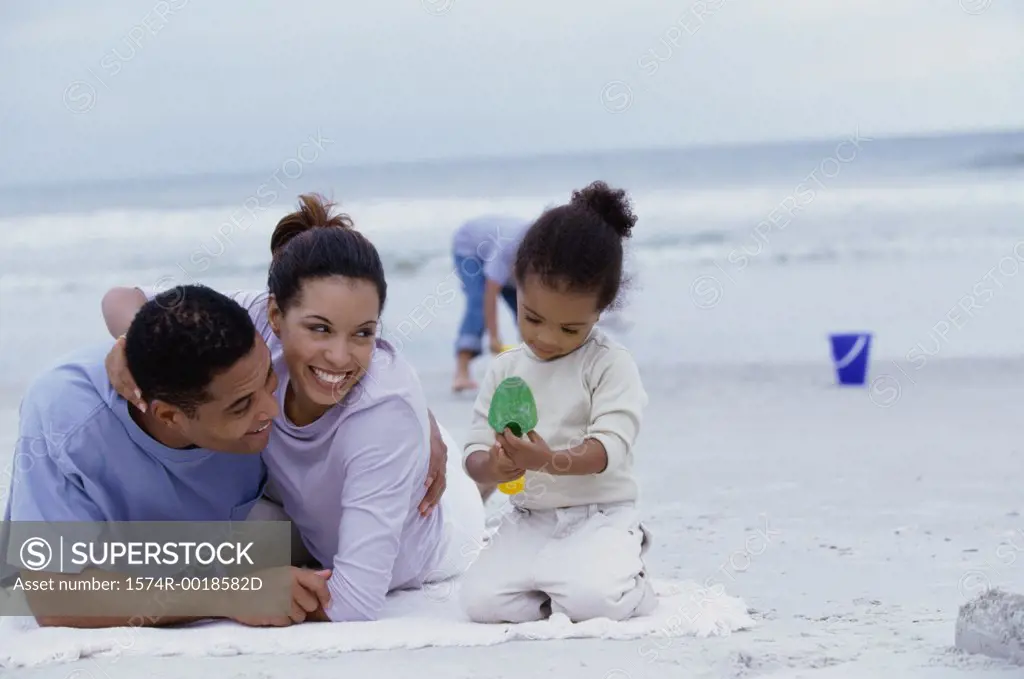 Parents playing with their daughter and son on the beach