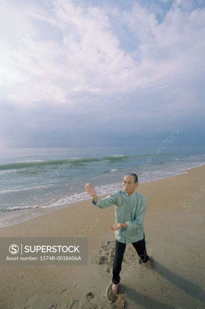 High angle view of a senior man practicing tai chi on the beach