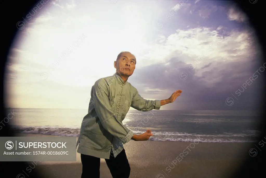 Senior man practicing tai chi on the beach